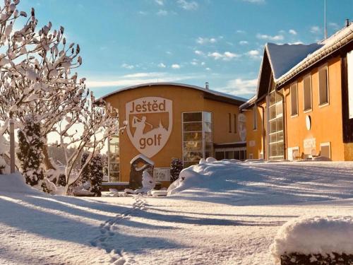 a building with snow on the ground in front of it at Exkluzivní chalupa Podještědka s grilem a saunou in Světlá pod Ještědem
