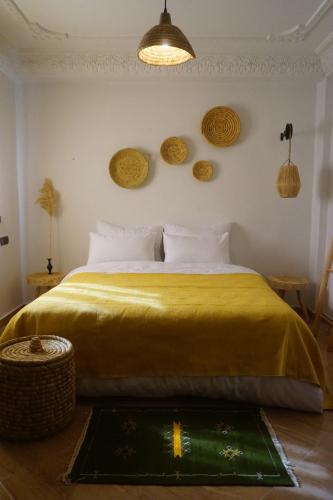 a bedroom with a large bed with a yellow blanket at Caban Surf in Tamraght Ouzdar