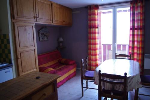 Zimmer mit einem Bett und einem Tisch sowie einem Zimmer mit einem Sofa in der Unterkunft Agréable Studio à 400 m du centre ville de Luz in Luz-Saint-Sauveur