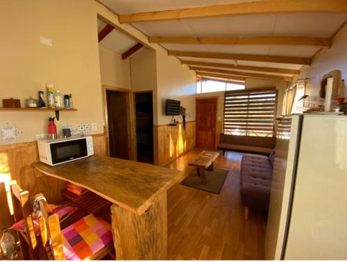 cocina y sala de estar con encimera y nevera en Cabañas Rukapillán Región de la Araucanía, en Villarrica