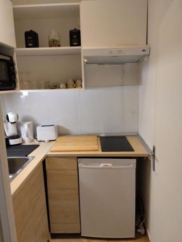 une petite cuisine avec un évier et une cuisinière dans l'établissement Le cercle doré, à Toulouse