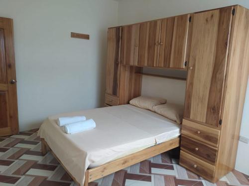 um quarto com uma cama e um armário de madeira em Departamento Crucita em Crucita