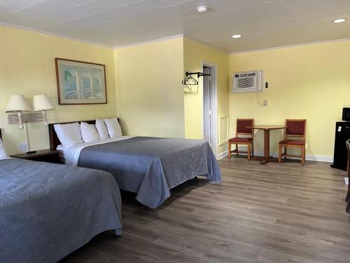 Habitación de hotel con 2 camas y mesa en Swell Motel en Buxton