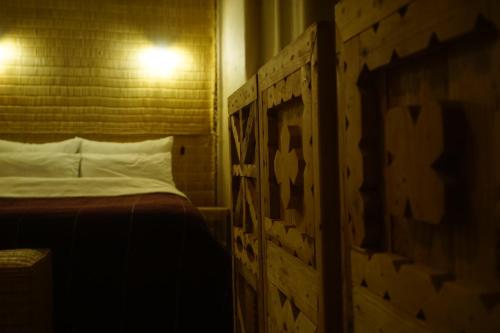 a bedroom with a bed with a wooden head board at Caban Surf in Tamraght Ouzdar