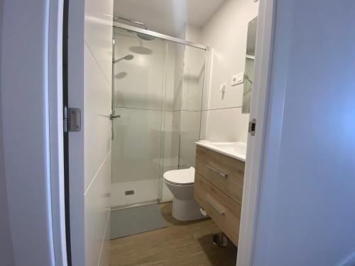 uma casa de banho com uma cabina de duche em vidro e um WC. em Estudio renovado con vista al mar em Torremolinos