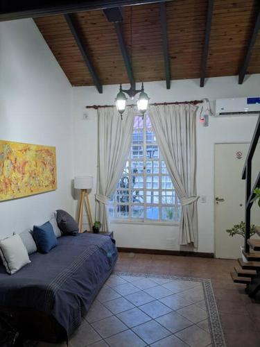 1 dormitorio con cama y ventana grande en Loft c/cochera en la mejor zona de Mendoza - Sol de los Andes en Mendoza