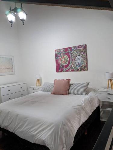 1 dormitorio con 1 cama blanca grande y 2 almohadas en Loft c/cochera en la mejor zona de Mendoza - Sol de los Andes en Mendoza