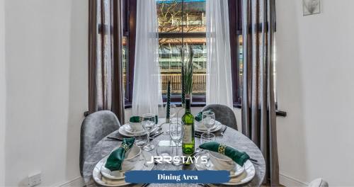 a table with wine bottles and glasses on it at Cardiff Stylish 2 Bedroom Sleeps 6 Wi-Fi - JRR Stays in Cardiff