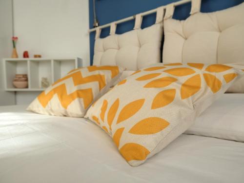 een bed met twee oranje en witte kussens erop bij Mind Tiny Home in Rho