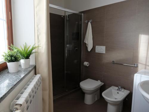 een badkamer met een douche, een toilet en een wastafel bij Mind Tiny Home in Rho