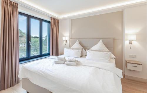 a white bed in a room with a large window at Eden in Binz