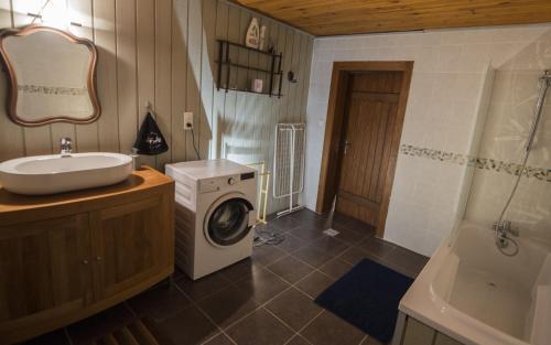 a bathroom with a washing machine and a sink at La Ferme des 3 lacs in Xonrupt-Longemer
