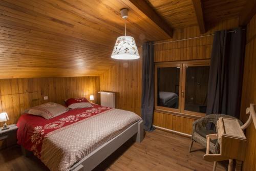 ein Schlafzimmer mit einem Bett in einem Holzzimmer in der Unterkunft La Ferme des 3 lacs in Xonrupt-Longemer