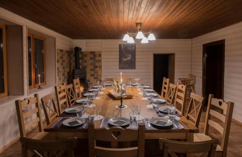 une salle à manger avec une longue table en bois et des chaises dans l'établissement La Ferme des 3 lacs, à Xonrupt-Longemer