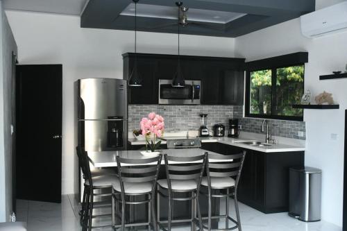 a kitchen with black cabinets and a table with chairs at Casa Proa in Uvita