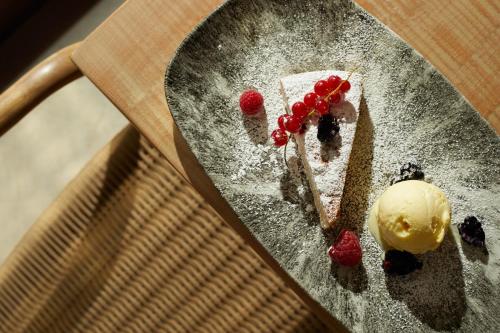 a piece of cake and berries on a plate with ice cream at Hotel Rural Es Riquers in Porreres