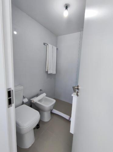a white bathroom with a toilet and a sink at SYRAH Premium B2 - Piscina privada con vista al mar by depptö in Punta del Este