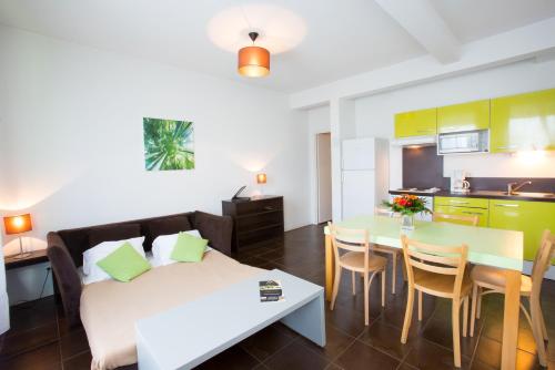 uma sala de estar com uma cama e uma mesa e uma cozinha em All Suites Bordeaux Lac - Parc des Expositions em Bordeaux