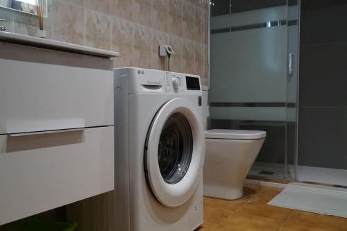 ein Badezimmer mit einer Waschmaschine und einem WC in der Unterkunft Apartamento las Palmeras in Roses