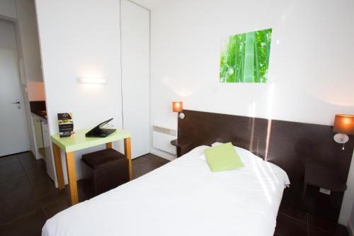 a hotel room with a bed and a telephone at All Suites Appart Hôtel - Bordeaux Lac in Bordeaux