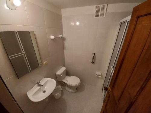 uma casa de banho com um lavatório, um WC e um espelho. em Oasis san José de la villa em Villa de Leyva