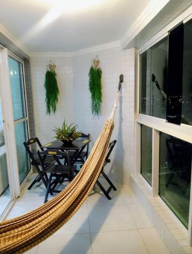 una hamaca en una sala de estar con mesa y sillas en Apartamento com 1/4 lindo e aconchegante na Praia, en Aracaju