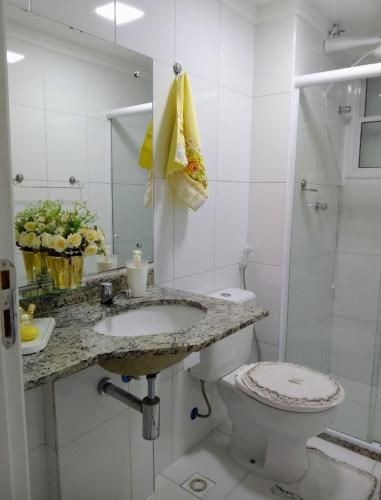 y baño con aseo, lavabo y ducha. en Apartamento com 1/4 lindo e aconchegante na Praia, en Aracaju