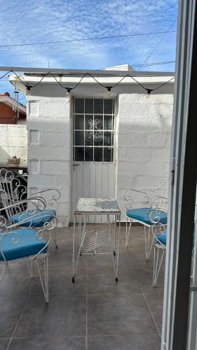 un patio con sillas, una mesa y una sombrilla en Duplex centro Carlos Paz en Villa Carlos Paz