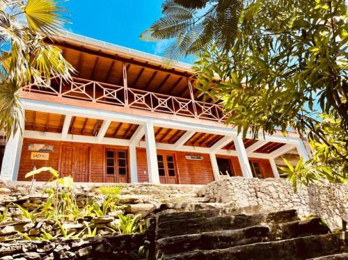 ein großes Gebäude mit einer Veranda darüber in der Unterkunft The Palms - Caribbean Paradise in Playa Aguadulce