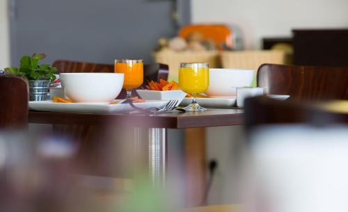 a table with bowls and glasses of orange juice at All Suites Appart Hôtel - Bordeaux Lac in Bordeaux