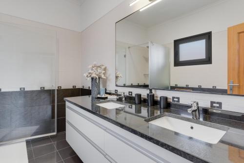 uma casa de banho com 2 lavatórios e um espelho grande em Casa Amarela em Funchal