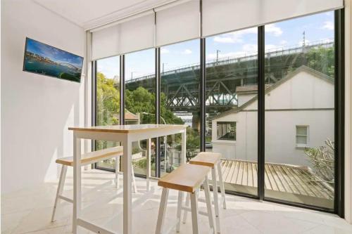 a room with a table and chairs and a large window at Panorama Firework View - Classic 4-Level Terrace Style Living in Kirribilli !!! in Sydney