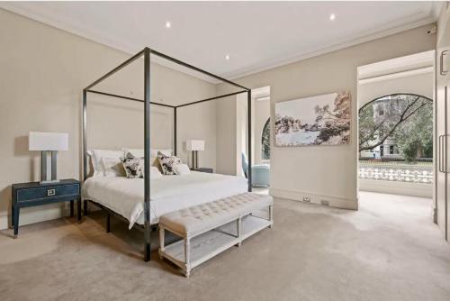 a bedroom with a canopy bed with a bench in it at The Kirribilli in Sydney