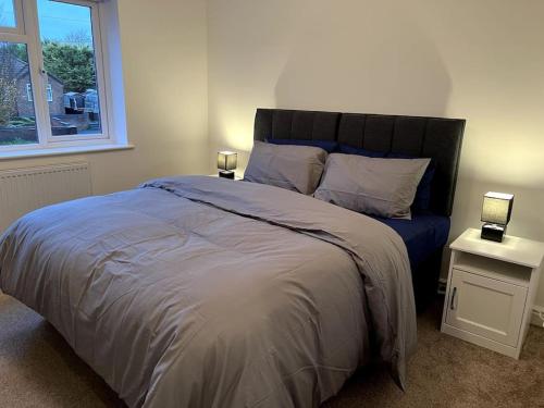 a bedroom with a large bed with two lamps on tables at Home in Barrow-Upon-Soar in Barrow upon Soar