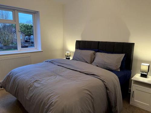 a bedroom with a large bed and a window at Home in Barrow-Upon-Soar in Barrow upon Soar