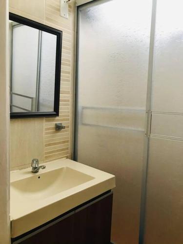 a bathroom with a sink and a mirror and a shower at Casa con piscina-Wifi alta velocidad in Lima