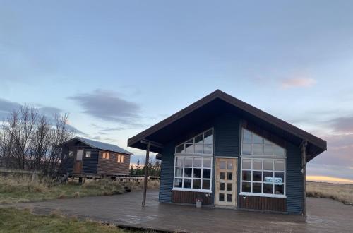 a small blue building with a large window at Myrarkot Country Home in Selfoss