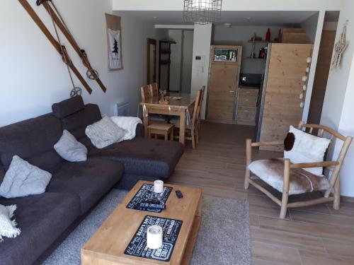 un salon avec un canapé et une table dans l'établissement Appartement montagne dans résidence, à Villard-de-Lans