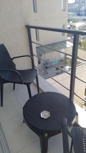 una mesa y sillas en un balcón con reloj en PLAZA376 2 en Chivilcoy
