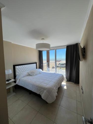 - une chambre avec un lit et une grande fenêtre dans l'établissement Ocean Blue, à San Clemente del Tuyú