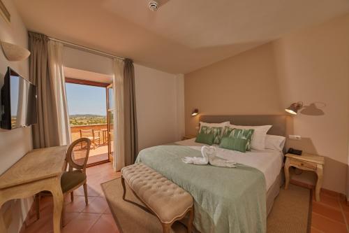 Hotel Rural Es Riquers في بوريراس: غرفة نوم بسرير كبير وبلكونة