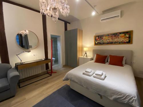 a bedroom with a large bed and a chandelier at Opera Suites Fidelio , cozy studio in the very center of Madrid in Madrid