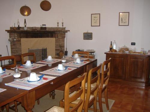 un comedor con una mesa larga y una chimenea en Agriturismo Cà Rossa, en Pegognaga
