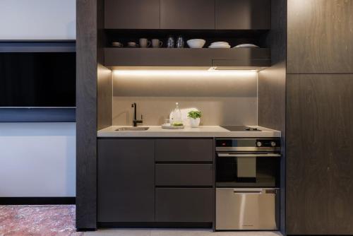 a kitchen with a sink and a stove at Veriu Queen Victoria Market in Melbourne