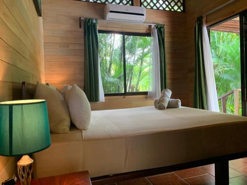 a bedroom with a large bed with a window at Ocean Melody 2 in Uvita