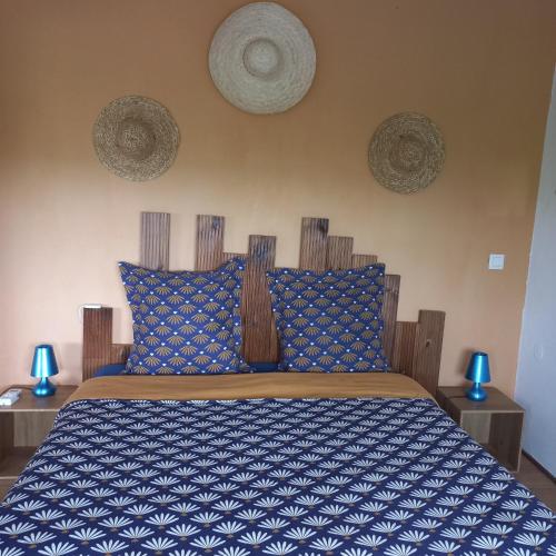 um quarto com uma cama com um edredão azul e branco em Lauraym2 em Baie-Mahault