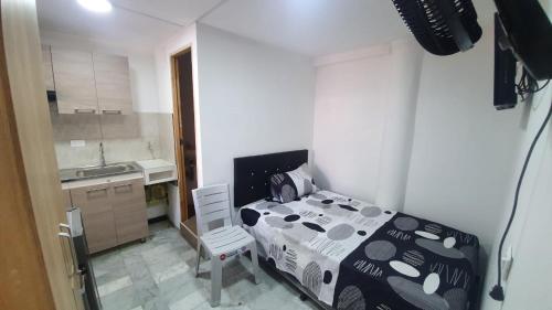um pequeno quarto com uma cama e uma cozinha em Pequeño apartaestudio em Medellín