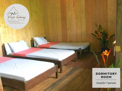 three beds in a room with a sign that says bathroom room at Cafe Sabang Guest House in Sabang