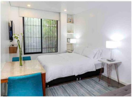1 dormitorio con 1 cama grande, mesa y sillas en Confortable apartamento con la perfecta ubicación!, en Bogotá