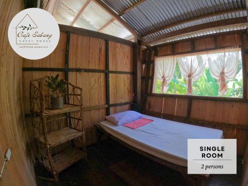 a small room with a bed and a window at Cafe Sabang Guest House in Sabang